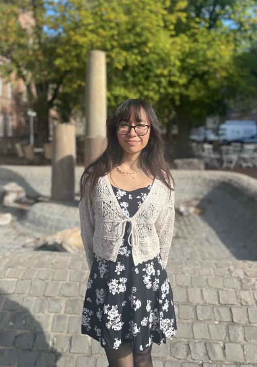 junge Frau mit Brille und dunklen langen Haaren im Sommerkleid