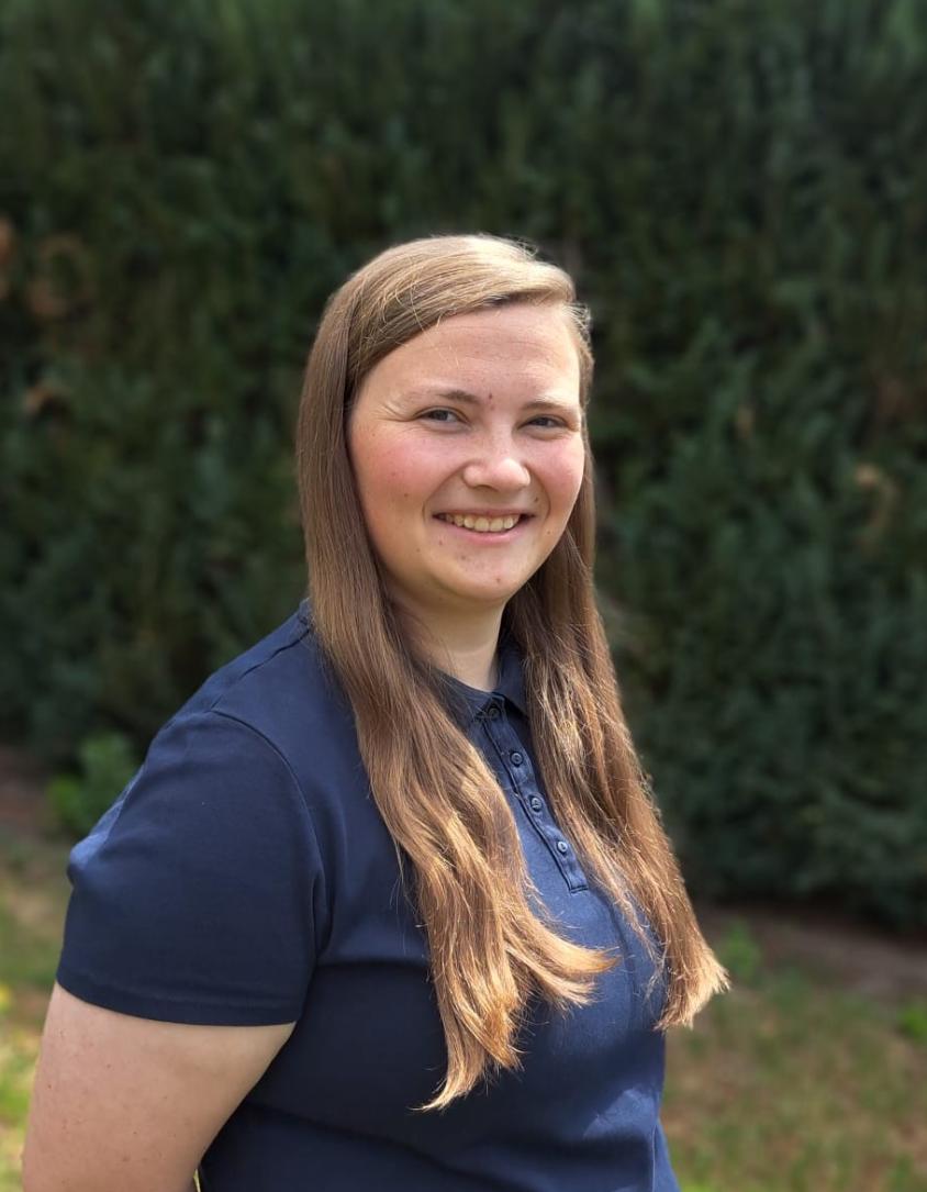 junge Frau mit langen braunen Haaren und blauem T-shirt